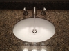 Widespread brushed nickel faucet with a white under mount sink.