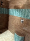 A cool, refreshing shower can be created with bright tile and chrome fixtures.  